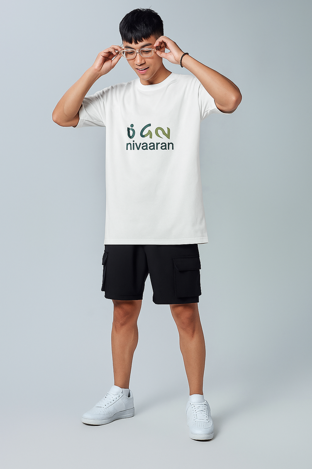 Person wearing a white t-shirt with 'nivaaran' logo on a gray background